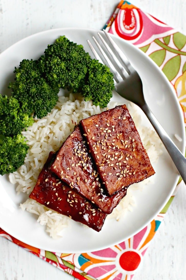 Sobrecarga de un plato de tofu teriyaki al horno sobre arroz al vapor con una guarnición de brócoli