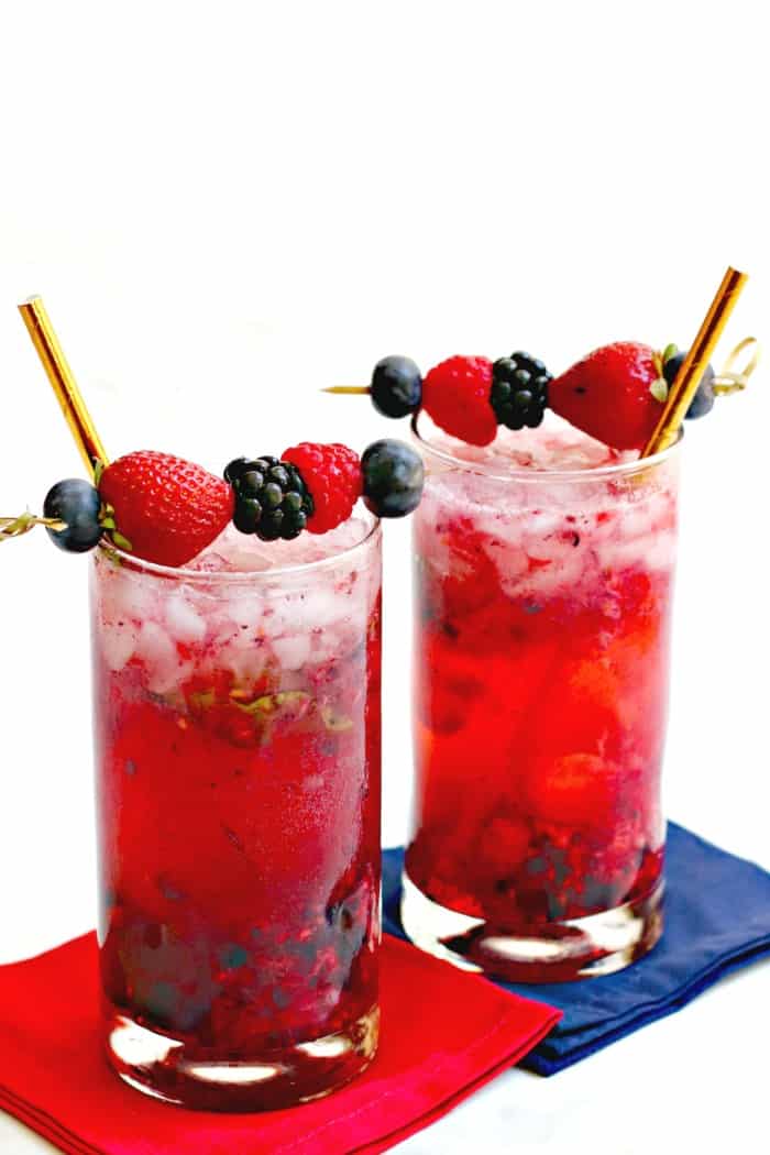 Cócteles Easy Berry Vodka con pajitas doradas en servilletas rojas y azules
