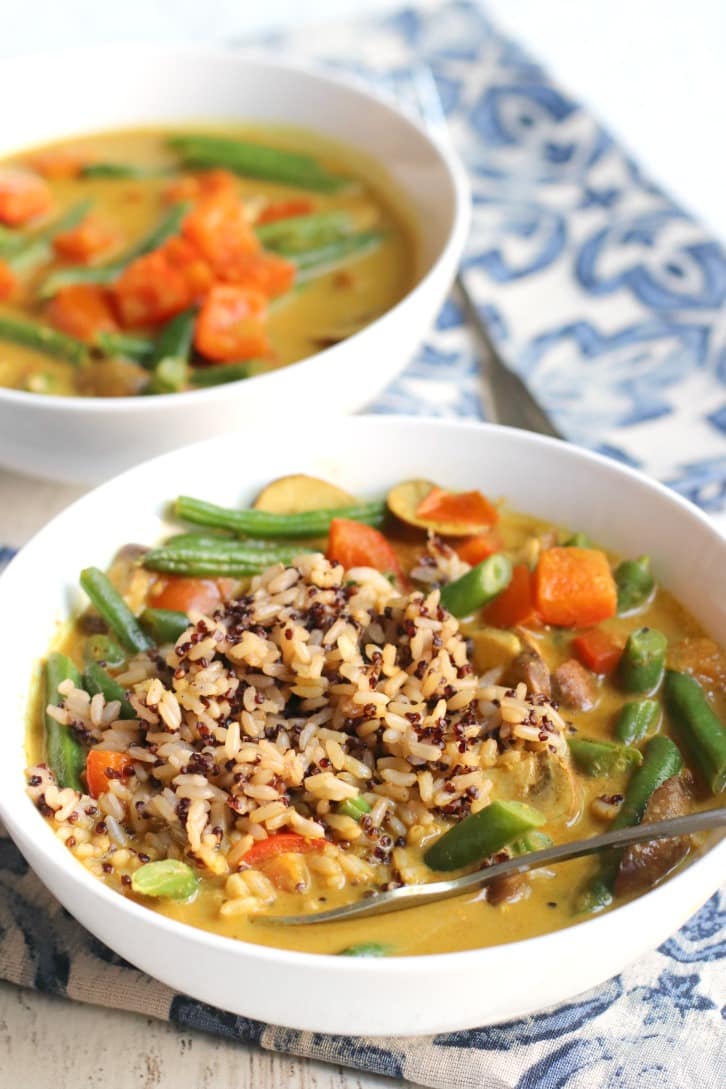 Curry de judías verdes cubierto con arroz integral y quinua con un tenedor.