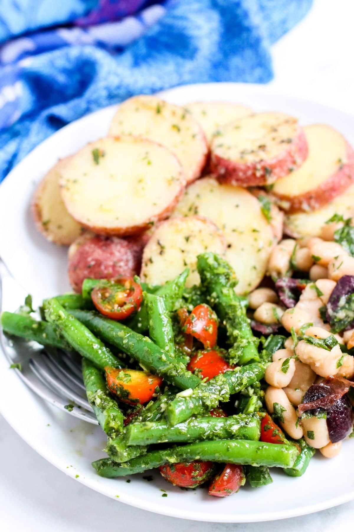 Plato de ensalada de patata, ensalada de judías cannellini y ensalada mediterránea de judías verdes
