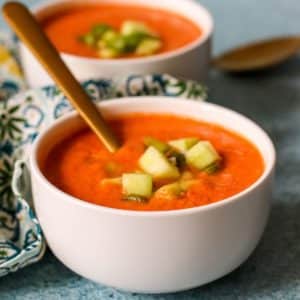Cuencos de sopa fría de tomate adornada con pepino y pimiento verde