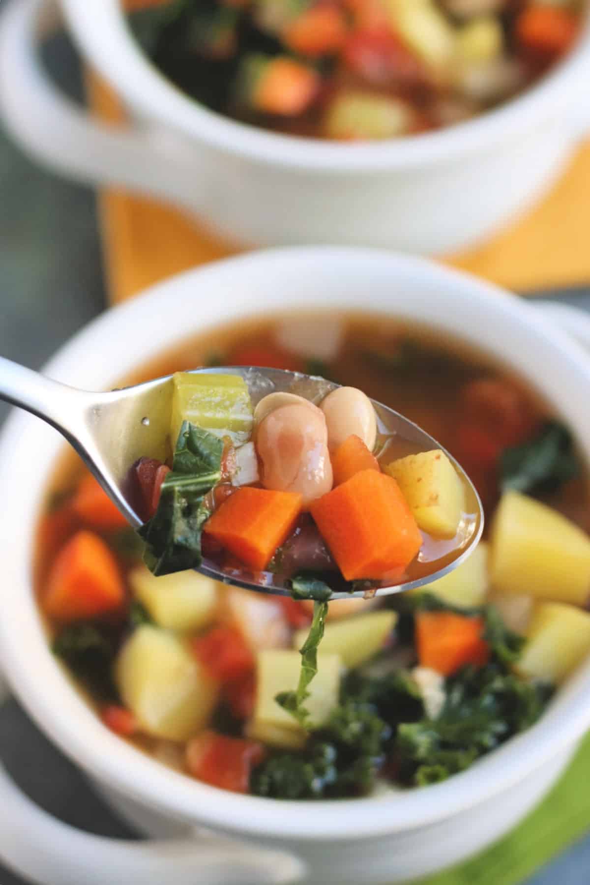 Primer plano de sopa de verduras veganas en una cuchara.