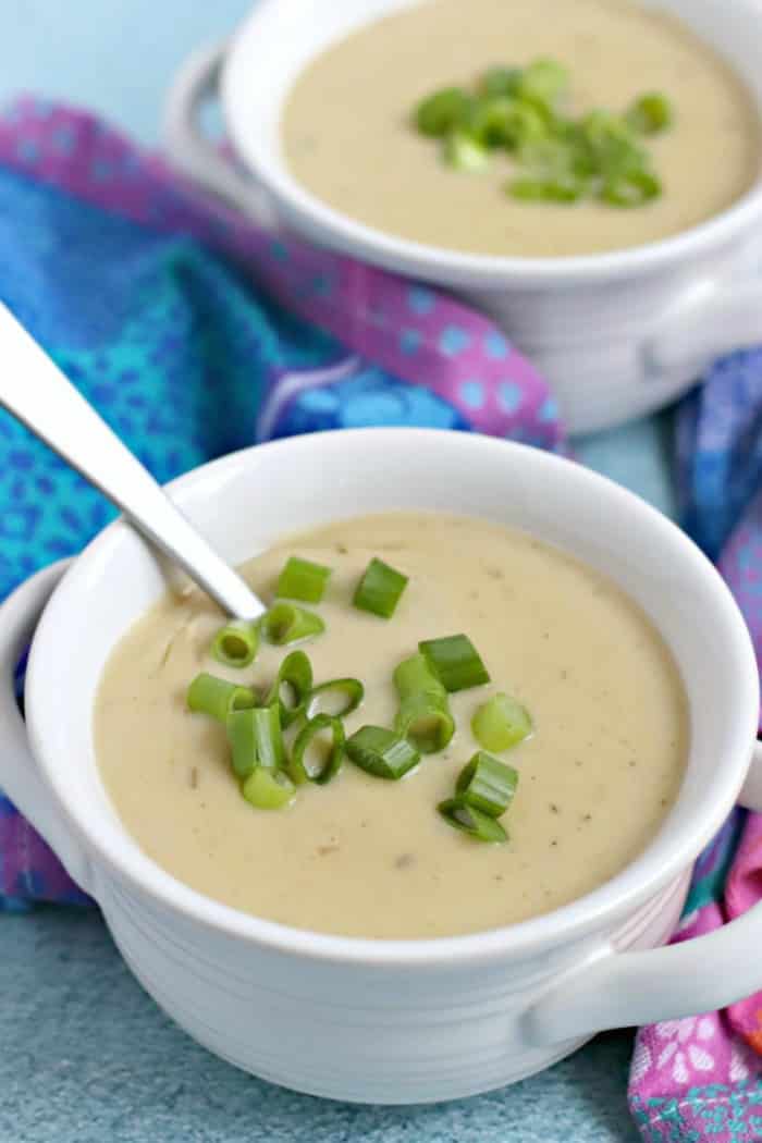Cuencos de sopa vegana de puerro y patata instantánea cubierta con cebollas verdes en rodajas